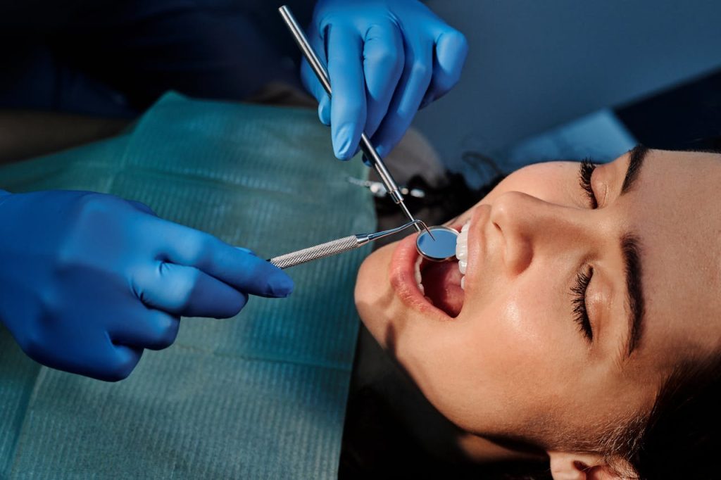 Close-up of a dentist examining a patients teeth using dental tools.